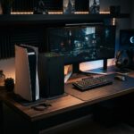 Dois consoles de videogame de ultima geracao posicionados lado a lado em uma mesa de jogos moderna com iluminacao suave.