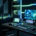 Console portatil moderno sobre uma mesa minimalista com iluminacao neon azul e verde.